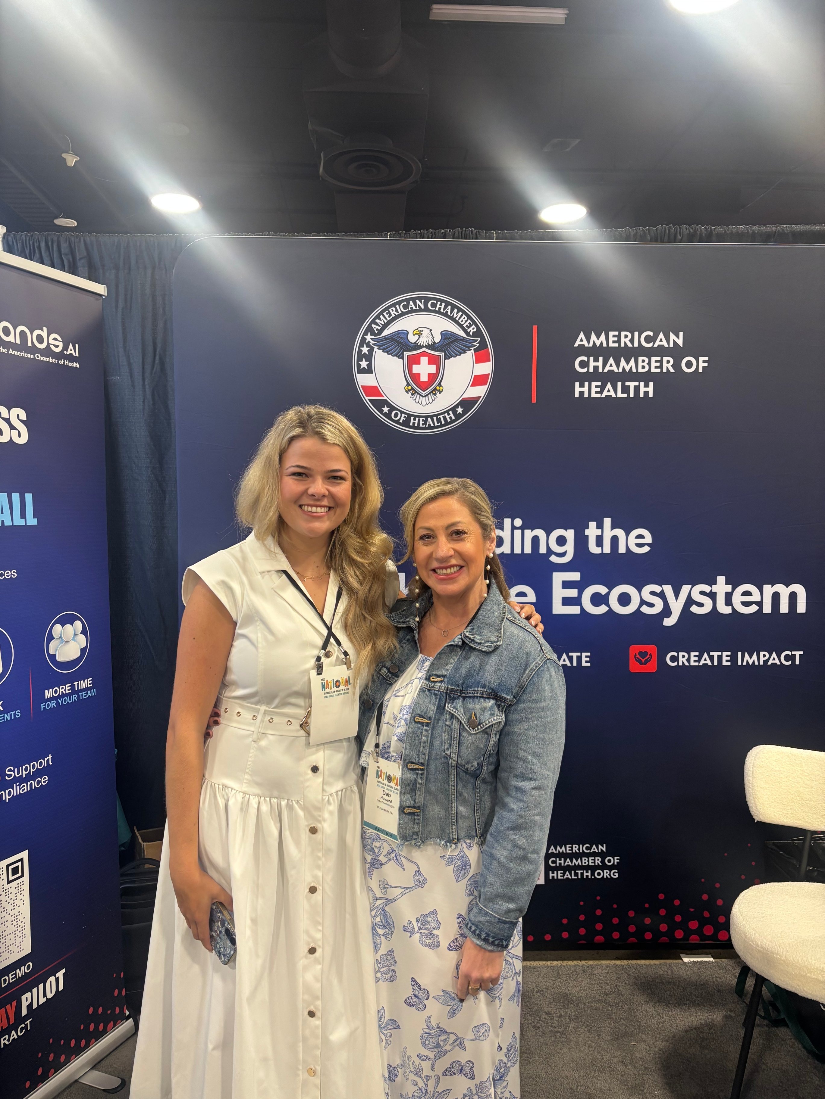 Two guests posing arm in arm at the ACH booth in Nashville
