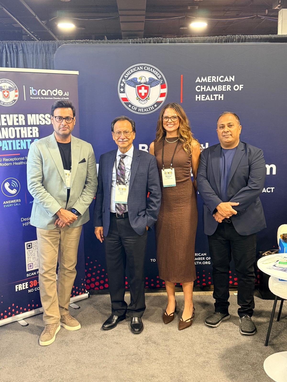 Khalid Sattar, Sam, and two team members at the ACH booth beside the iBrands.ai banner