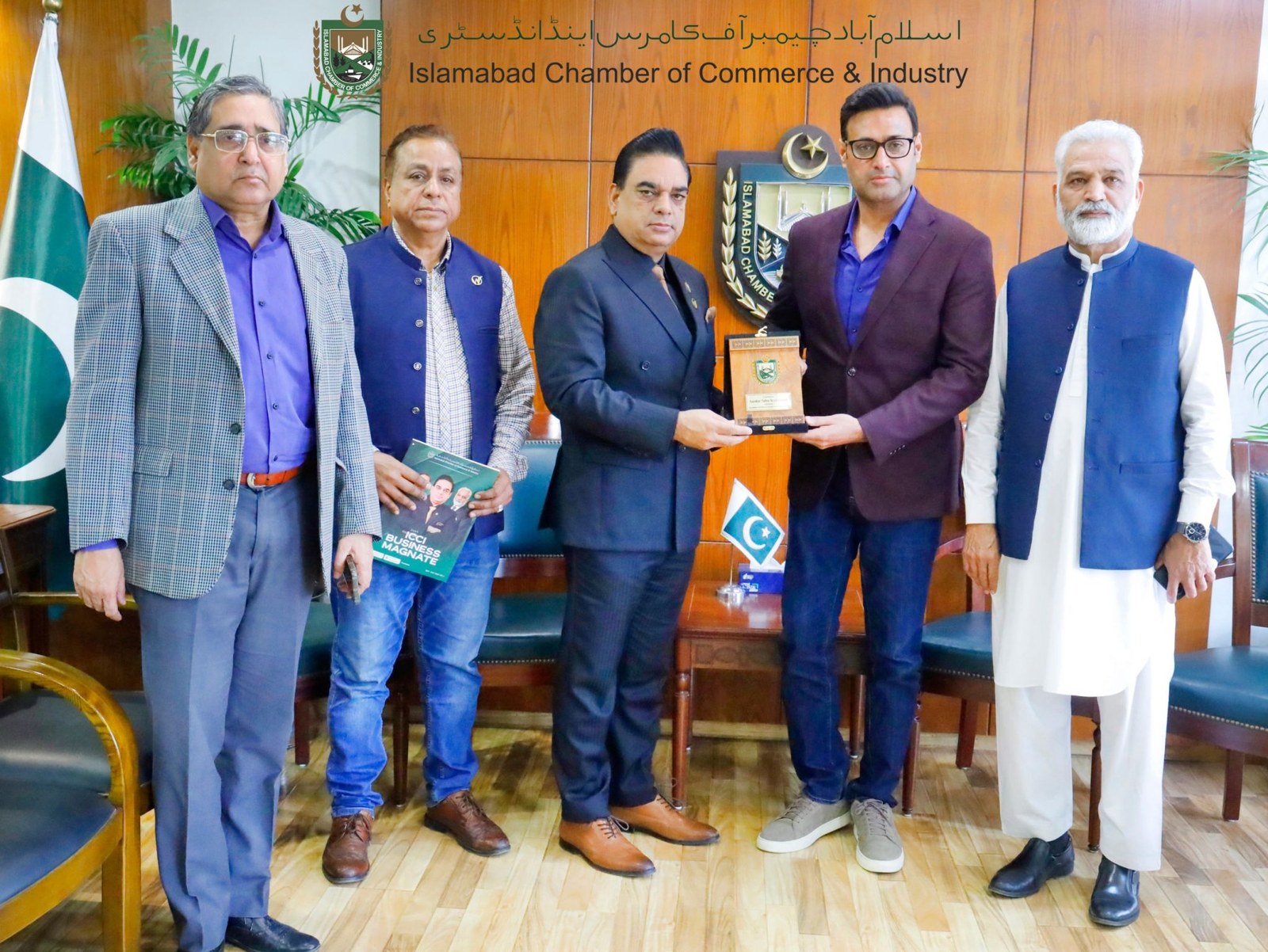 Muhammad Khalid accepts a plaque from an ICCI official inside the chamber offices