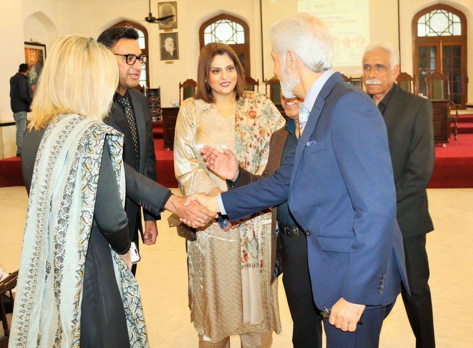 Muhammad Khalid greets an attendee in the summit hall at KEMU