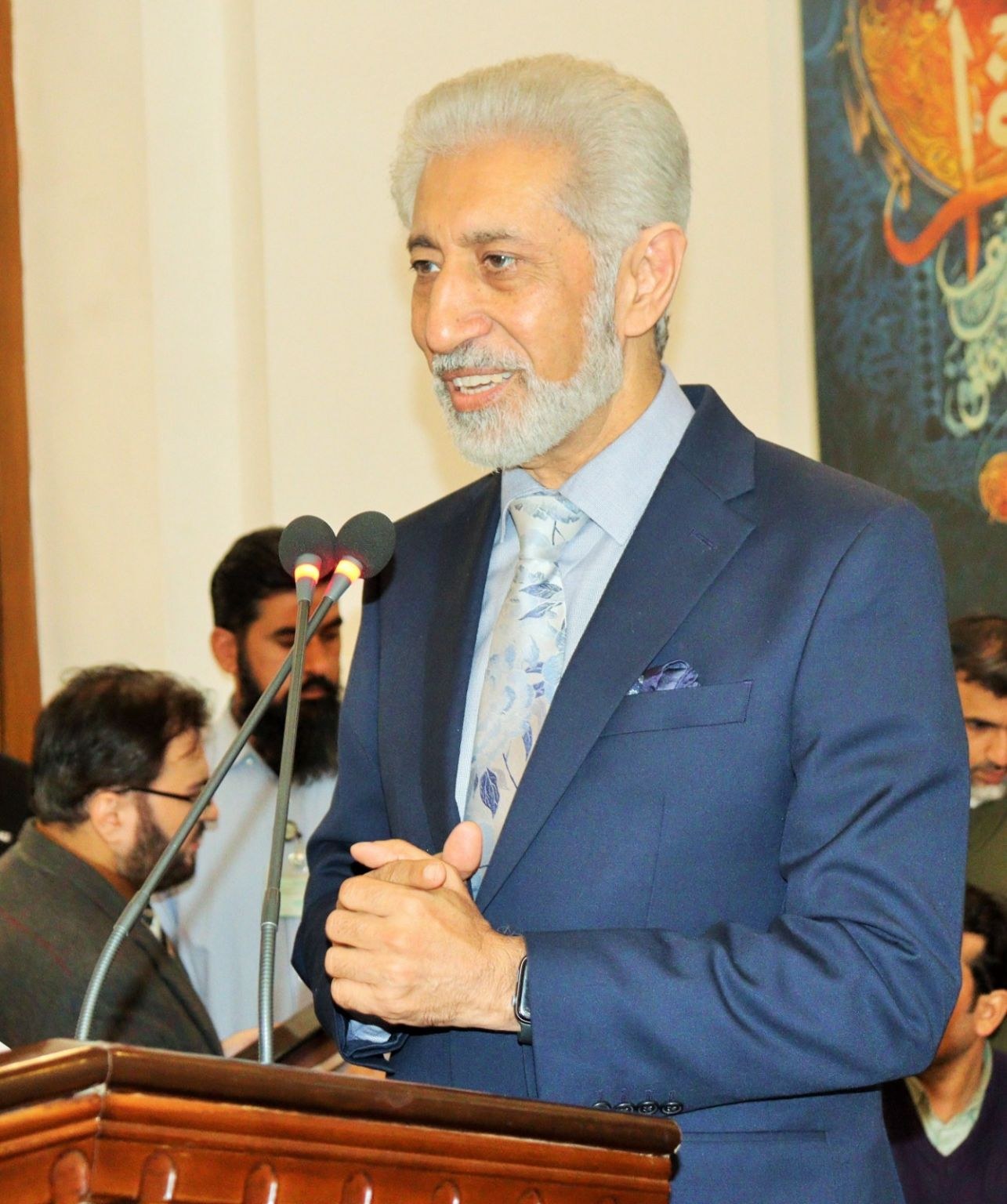 A senior speaker addresses the delegates from the podium in Lahore